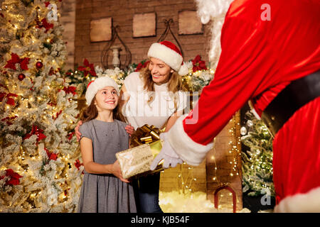 Babbo Natale dà un regalo ad una ragazza per il natale. Foto Stock