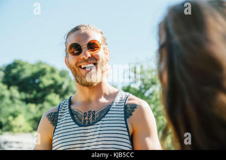 Uomo caucasico con petto tattoo ridendo all'aperto Foto Stock