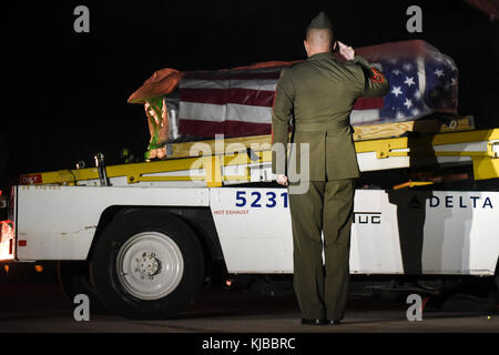 Gunnery Sgt. Nicholas Brundige, Assistente Marine Corps direttore funebre, Marine sede caserma, Washington D.C., saluta la bandiera draged scrigno contenente i resti del Marine Corps Pvt. Vernon Paolo Keaton, come esso si sposta verso il basso il nastro trasportatore dopo arriva al Will Rogers World Airport Novembre 14, 2017, Oklahoma City, Oklahoma. Keaton è stato ucciso 7 dicembre, 1941, e i suoi resti sono stati recentemente identificati positivamente dal Dipartimento della Difesa per internamento. (U.S. Air Force foto/Greg L. Davis) Foto Stock