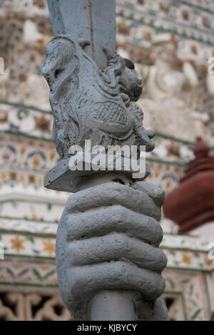 Dettaglio di un drago sulla base di una spada la statua di pietra di un tutore Cinese presso l'entrata di Wat Arun, Bangkok, Thailandia. Foto Stock