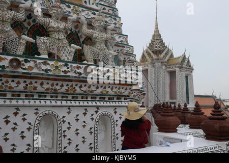 Un turista è scattare una foto di Wat Arun, il tempio dell'alba sulle rive del Fiume Chao Praya, restaurato e riaperto al pubblico nel 2017, a Bangkok. Foto Stock