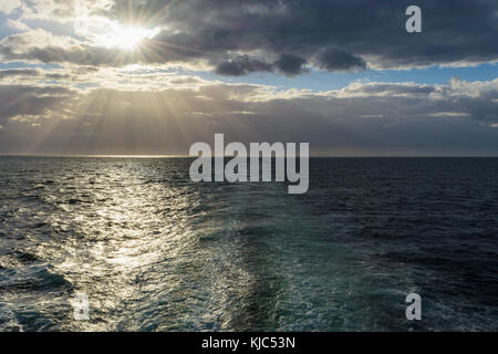 la scia della nave con il sole che splende attraverso le nuvole sul Mare del Nord, Regno Unito Foto Stock