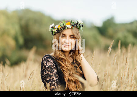 Medio Orientale donna che indossa la corona di fiori nel campo Foto Stock