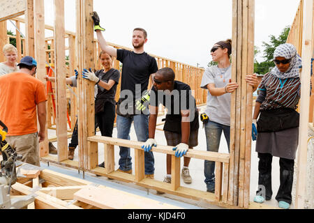 I volontari di contenimento parete incorniciato al sito in costruzione Foto Stock