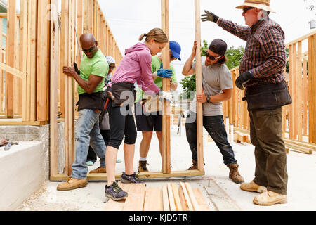 I volontari di sollevamento parete incorniciato al sito in costruzione Foto Stock