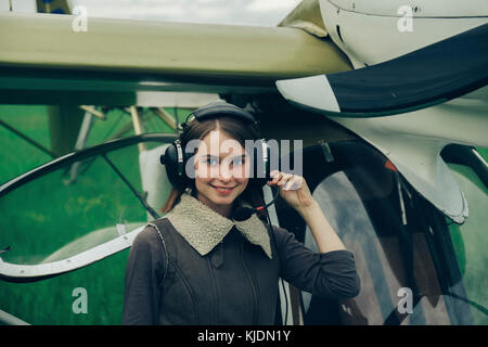Caucasian donna che indossa una cuffia vicino in aereo Foto Stock