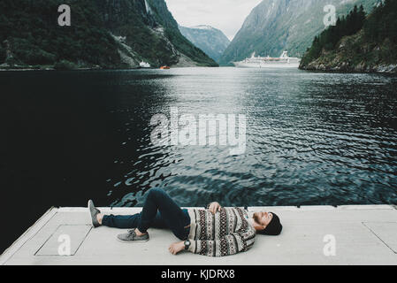 Uomo caucasico posa sul dock a waterfront Foto Stock