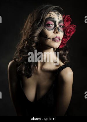 Messicano bella donna americana celebra Día de los Muertos ( Día de Muertos ) è la vacanza messicana noto anche come il Giorno dei Morti con cranio trucco e Roses nello stile di Catrina. Foto Stock