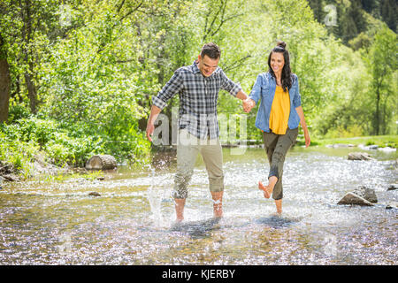 Donna calci acqua sull'uomo nel fiume Foto Stock