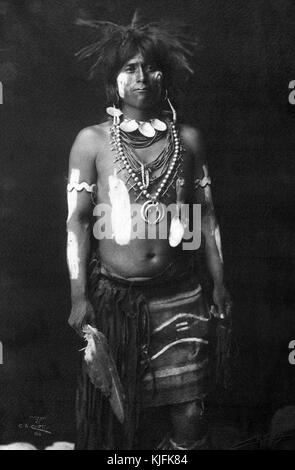 Ritratto fotografico di un ballerino Hopi Snake in costume, portava una piuma d'aquila, una frusta di serpente e un piccolo sacchetto di pasto di mais, sarebbe stato un partecipante ad una danza di sedici giorni, 1900. Dalla Biblioteca pubblica di New York. Foto Stock