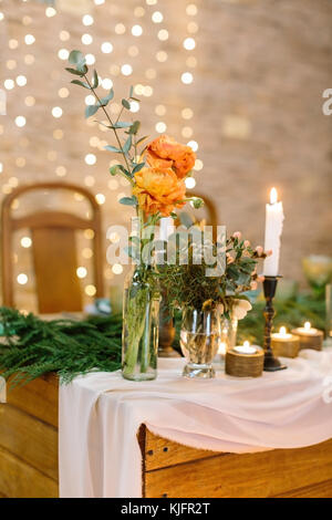 Il decor, romanticismo, dating concetto. close up di due posies in diverse forme in vasi trasparenti, che sono collocati sul bordo del tavolo da pranzo sullo sfondo delle luci blured Foto Stock