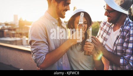 Gruppo di amici felice avente parte sul tetto Foto Stock