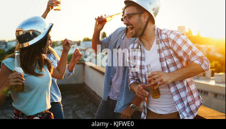 Gruppo di amici felice avente parte sul tetto Foto Stock