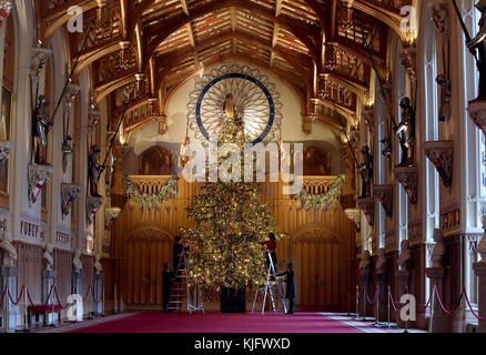 I membri del personale del Royal Collection Trust applicano i tocchi finali ad un abete Nordmann di 20 piedi nella St George's Hall nel Castello di Windsor, Berkshire. Foto Stock