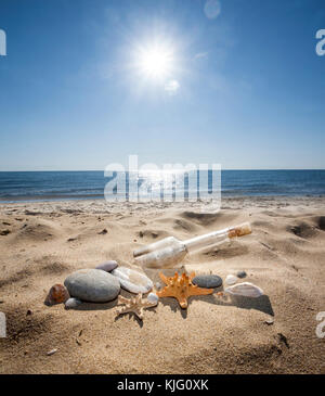 Bottiglia con un messaggio sulla spiaggia del mare Foto Stock