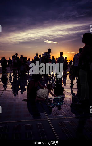 Le persone si radunano al tramonto su il saluto al sole installazione d arte in Zadar, Croazia Foto Stock