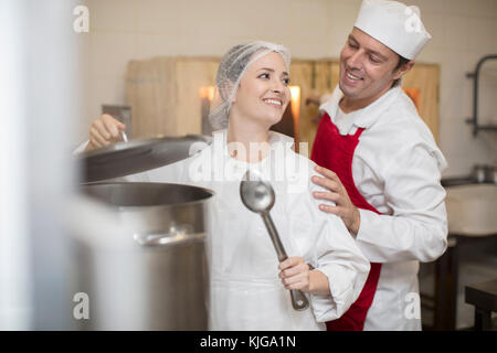 L uomo e la donna per la cottura in una mensa cucina Foto Stock