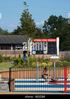 Viste intorno centrale rialzata area giardino con Tote board. Originariamente utilizzato per visualizzare quote scommesse / prezzi. Walthamstow Stadium Housing Development, Wa Foto Stock