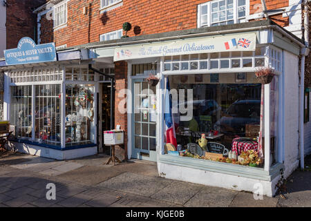 Delicatessen e negozi di antiquariato uno accanto all'altro su tenterden high street nel tardo pomeriggio di sole d'inverno, kent, Regno Unito Foto Stock