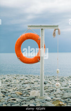 Ciambella arancione sulla costa del mare Foto Stock