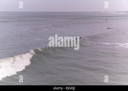 Surfers nel mare del Nord a saltburn dal mare nel North Riding dello Yorkshire su un giorno inverni, surf onde. Foto Stock