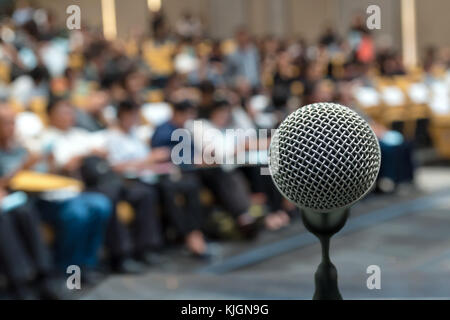 Microfono su astratto foto sfocata della sala conferenze o sala seminario con lo sfondo dei partecipanti Foto Stock