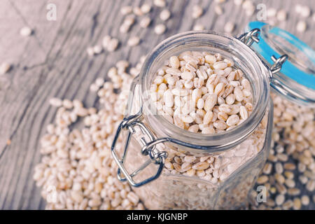 Orzo perlato grani in un vasetto di vetro Foto Stock