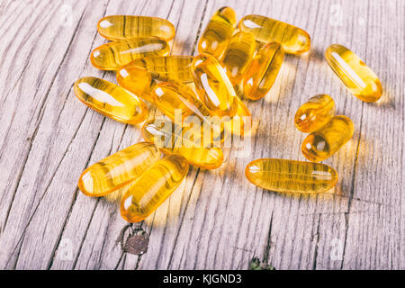 Close up di omega-3 grassi del pesce capsule di olio su tavola di legno Foto Stock