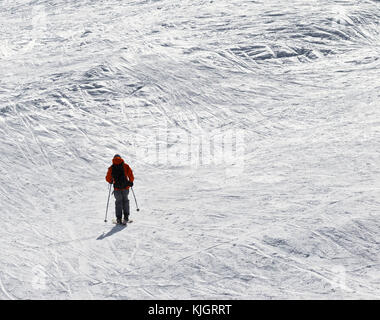 Sciatore in discesa su terreni innevati fuoripista in pendenza sun giornata invernale Foto Stock