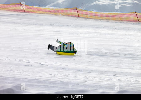 Snow tubing sulla stazione sciistica a sun giornata invernale Foto Stock