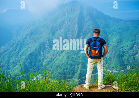 Il giovane uomo sorge sulla sommità del piccolo Adam's Peak e orologi foggy ella rock, sri lanka. Foto Stock