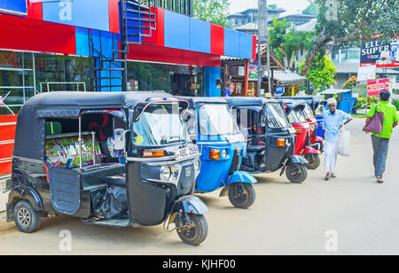 ELLA, SRI LANKA - 1 DICEMBRE 2016: La fila di tuk tuk, parcheggiata nella strada dello shopping accanto ai caffè turistici e negozi, il 1 ° dicembre a Ella. Foto Stock