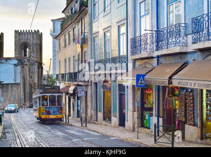 Lisbona, Portogallo - Dic 07, 2016: Tram 28 sulla strada di Alfama. Quartiere Alfama è il centro storico di Lisbona, famosa attrazione turistica. Foto Stock