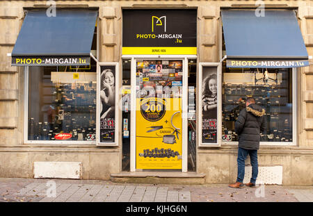 Un uomo alla ricerca di una fotocamera di fronte alla telecamera di store Foto Stock