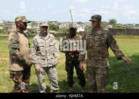 Spc. Andrew Rikard, a destra, un materiale esplosivo tecnico con il 764th Ordnance Company (l'eliminazione degli ordigni esplosivi) fuori di Ft. Carson, Colo., discute il set up per un esercizio pratico con MAJ Rene Didier Bekada con l'aiuto del traduttore Lt. Col. Daniel Ebert del XVIII Air Force sede fuori di Scott AFB, Ill. a esercitare contro-IED sconfitta in fase I di Douala in Camerun il 14 novembre 2017. L'eliminazione degli ordigni esplosivi è rilevante per le truppe camerunesi, che distribuiscono il lago Ciad Bacino di lotta Boko Haram e di altre organizzazioni terroristiche. (U.S. Foto dell'esercito da 1Lt. Eric Smith Foto Stock