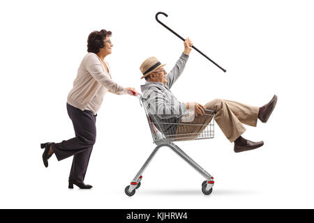 Lunghezza piena ripresa del profilo di una donna anziana spingendo un carrello con un Senior in sella all'interno isolato su sfondo bianco Foto Stock