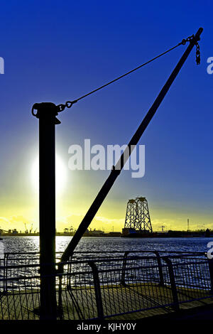 Fiume Tyne piccola barca derrick con sfondo di turbine eoliche in attesa di trasporto per il mare del Nord Foto Stock