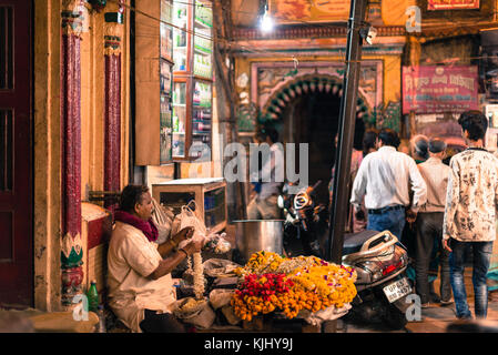 Varanasi, India - 14 marzo 2016: immagine orizzontale indiana di vecchio uomo che vendono fiori per la cerimonia aarti di Varanasi (India). Foto Stock