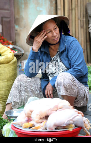 La donna nel cappello conico Vendita di polli. Hoi An. Il Vietnam. Foto Stock