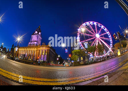 Il traffico che passa luna park e le luci di Natale da leeds town hall al crepuscolo Yorkshire Regno Unito Foto Stock