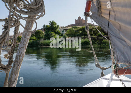 Vista di Aga Khan iii mausoleo e le verdi sponde del fiume Nilo a partire da un tradizionale feluca vicino alla città di Assuan, Egitto Foto Stock