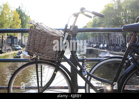 Bicicletta su un ponte sul canale Singel, nel sole autunnale, ad Amsterdam, nei Paesi Bassi Foto Stock
