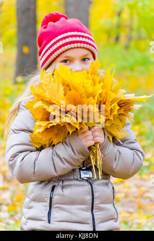 Foto della ragazza con bouquet da fogli in autunno Foto Stock