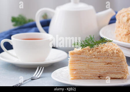 Round multi-layered Napoleone torta con crema pasticcera, su un azzurro sfondo tabella. il fuoco selettivo. cucina russa. Foto Stock