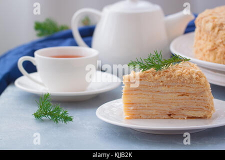 Round multi-layered Napoleone torta con crema pasticcera, su un azzurro sfondo tabella. il fuoco selettivo. cucina russa. Foto Stock