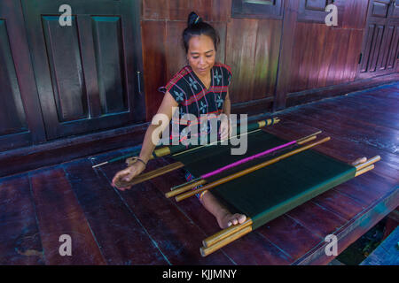 Una donna dalla minoranza Cotu si intreccia con una fascetta telaio in Quang Nam Vietnam Foto Stock