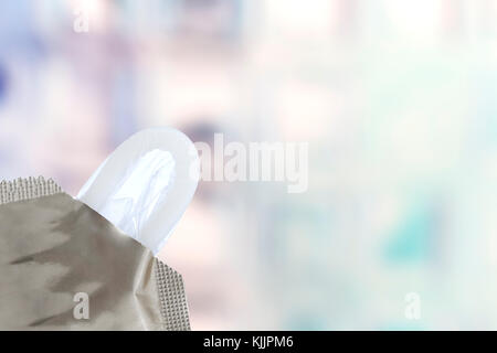 Il preservativo close-up isolato contraccettivo. in uscita dal pack su sfondo blury Foto Stock