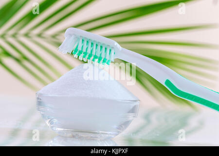 Vista superiore del bicarbonato di sodio ciotola con spazzolino da denti su bianco Foto Stock