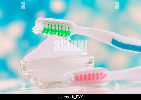 Vista superiore del bicarbonato di sodio ciotola con spazzolino da denti su blu Foto Stock