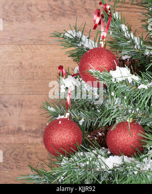 Red Ornamenti natale appeso a un albero con fondo in legno Foto Stock